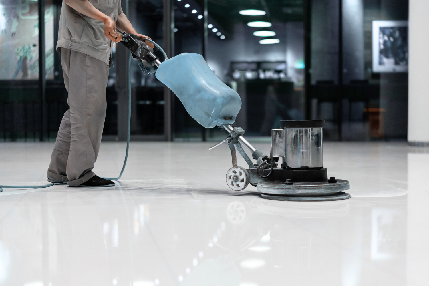 Person using a floor polishing machine on a shiny floor