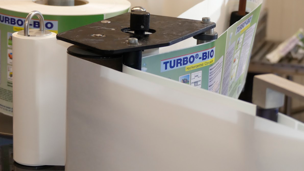 Roll of paper with 'Turbo Bio' branding on a machine.