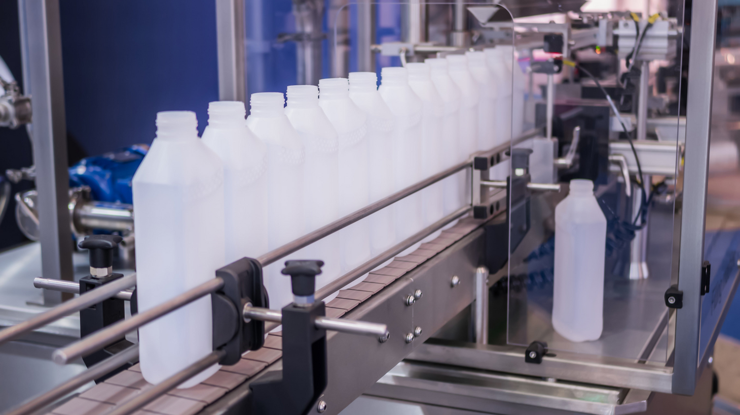 A row of empty bottles in the machine at the factory