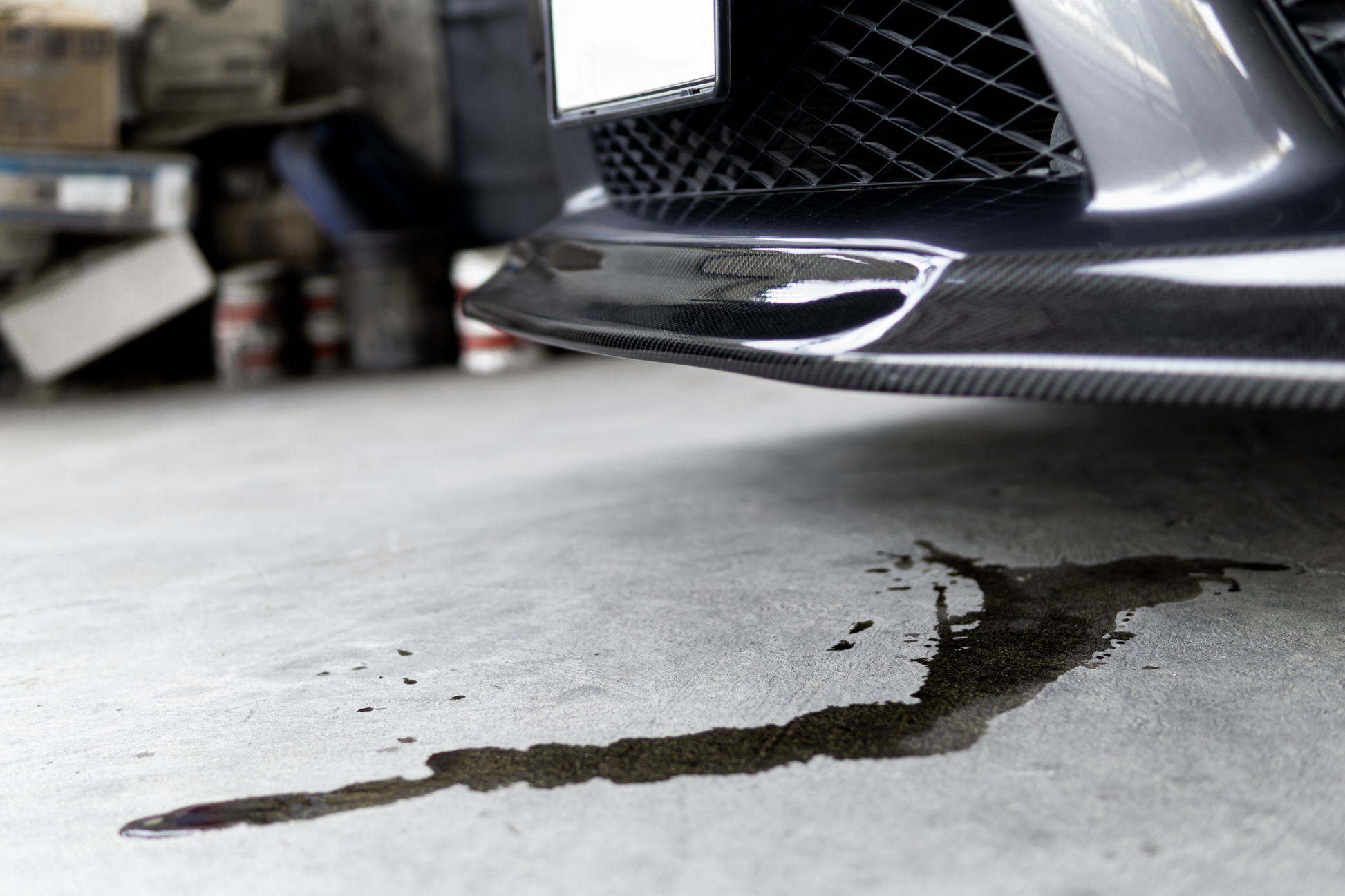 Car with oil spill on a concrete floor in a garage