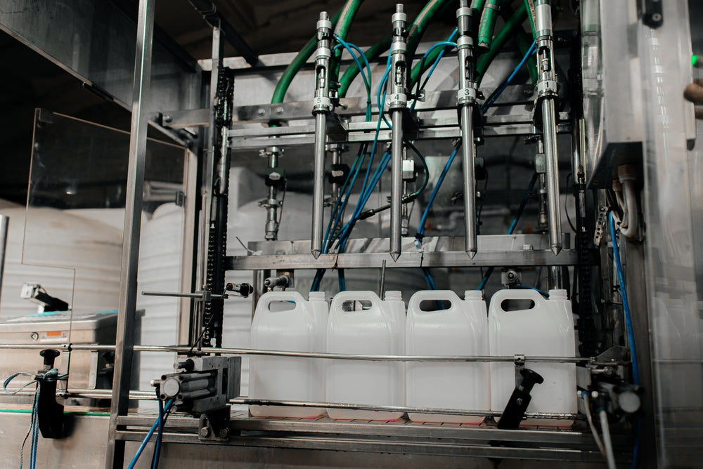 Automated machine filling white containers with a industrial setting.