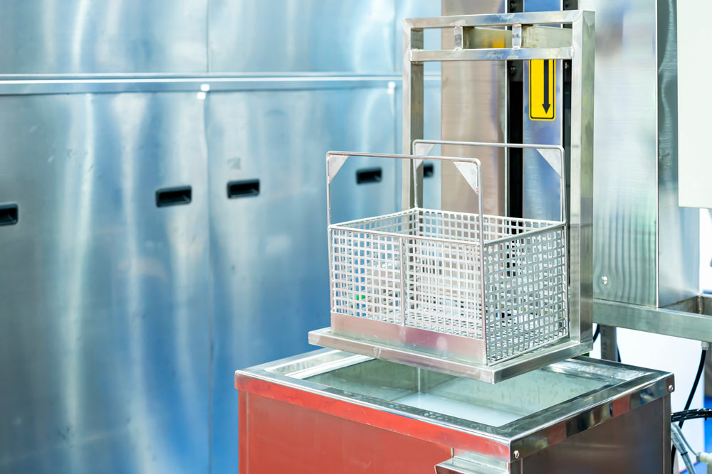 Close up empty stainless basket of ultrasonic cleaning machine on water tank